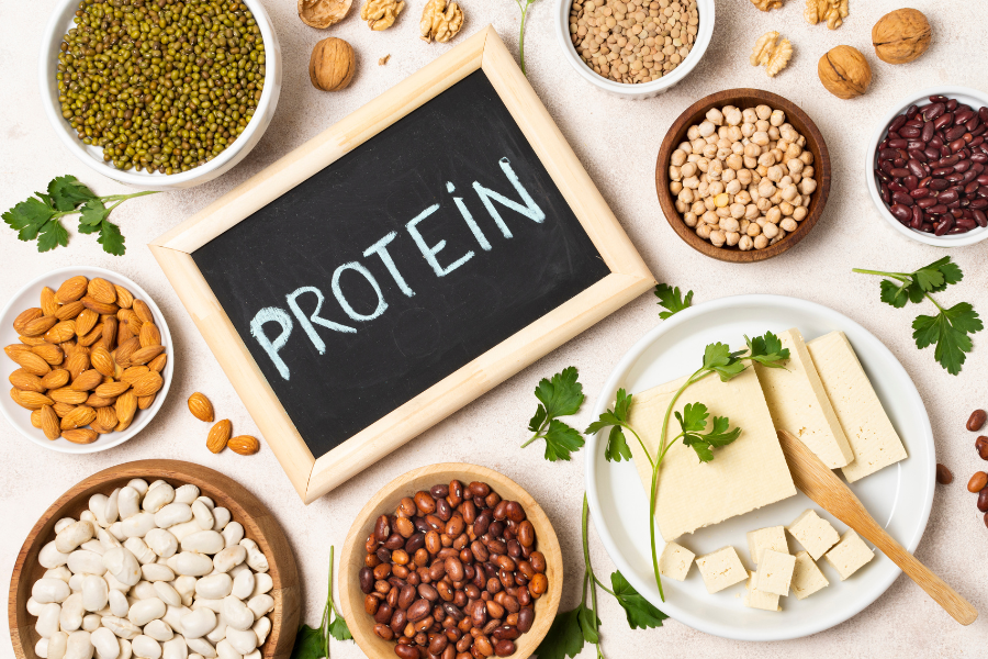 “Diferentes fontes de proteína em prato: ovos, frango, legumes e whey protein”